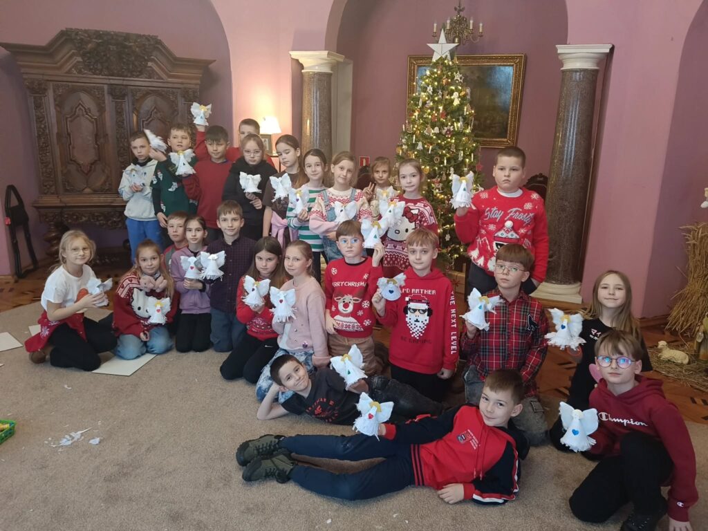 uczniowie z papierowymi aniołami