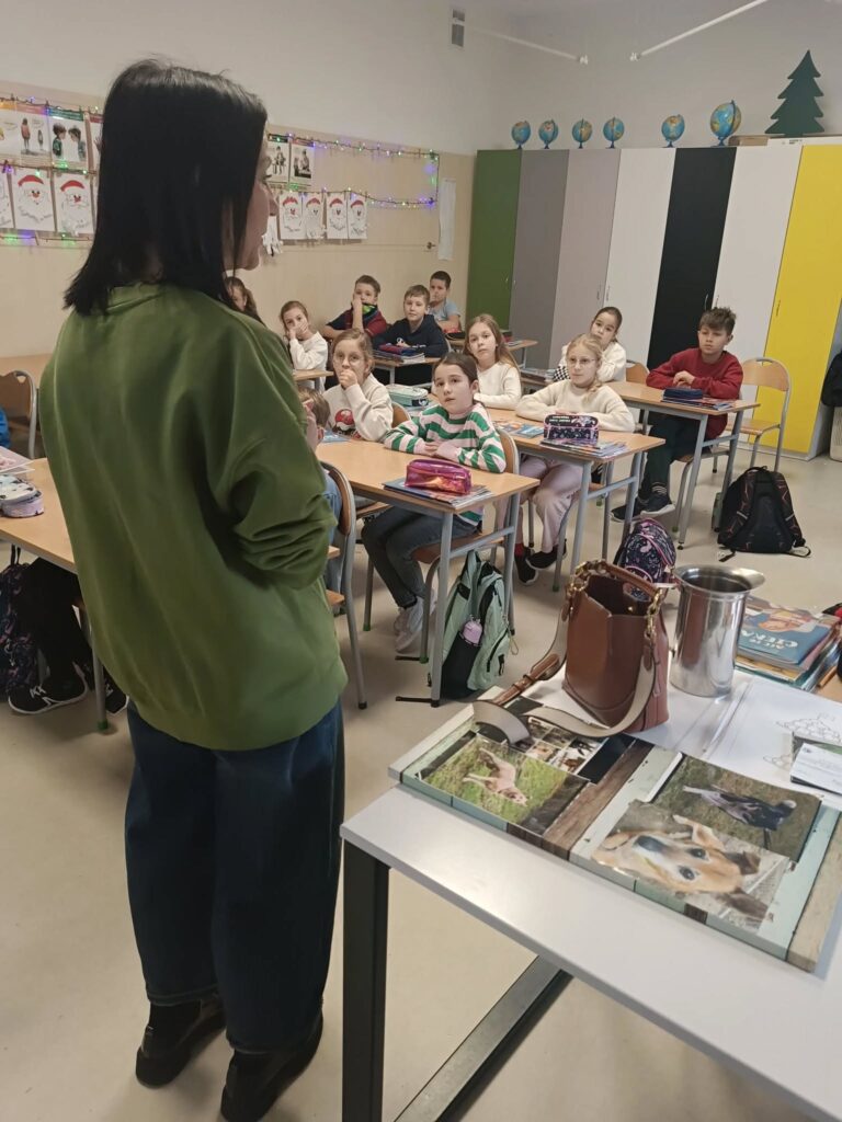 uczniowie i prowadząca prezentację o zwierzętach